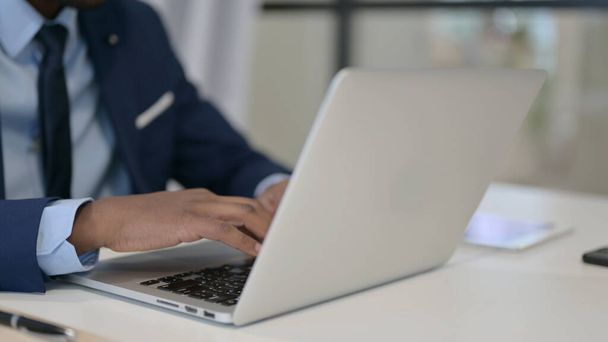 Empresario africano escribiendo en el ordenador portátil, de cerca - Foto, Imagen