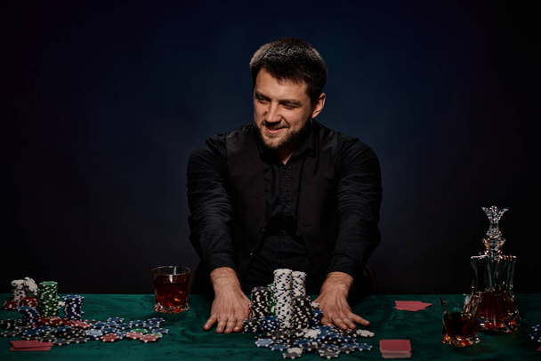 Bearded casino player man playing poker on green table - Fotografie, Obrázek