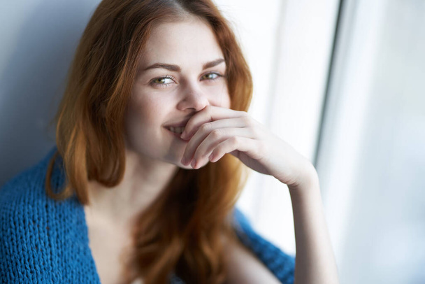 žena sedící u okna s modrým kostkovaným ránem - Fotografie, Obrázek