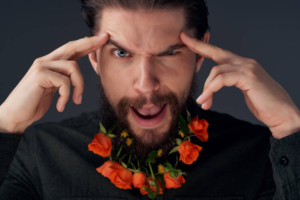 портрет человека, позирующего цветами в бороде - Фото, изображение
