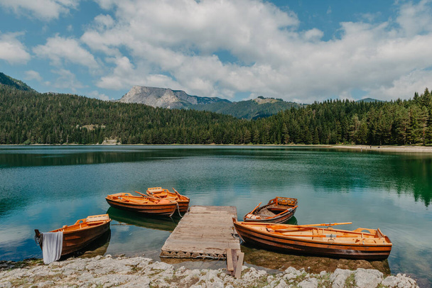 Boats on Black Lake - Crno jezero , northern Montenegro. It is a glacial lakeon the Mount Durmitor, on an altitude of 1,416 m. Black lake in Durmitor national park in Montenegro, Europe. Beauty world. - 写真・画像