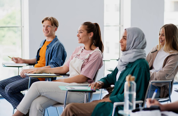 Group of multiethnic university students sitting in classroom indoors, studying. - Фото, зображення