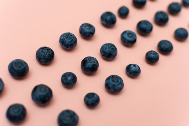 Blueberries arranged in rows on an old pink background - Foto, imagen
