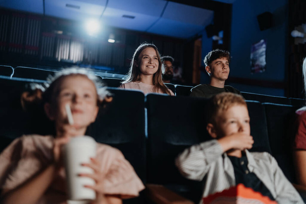 Cheerful young couple in the cinema, watching film. - Zdjęcie, obraz