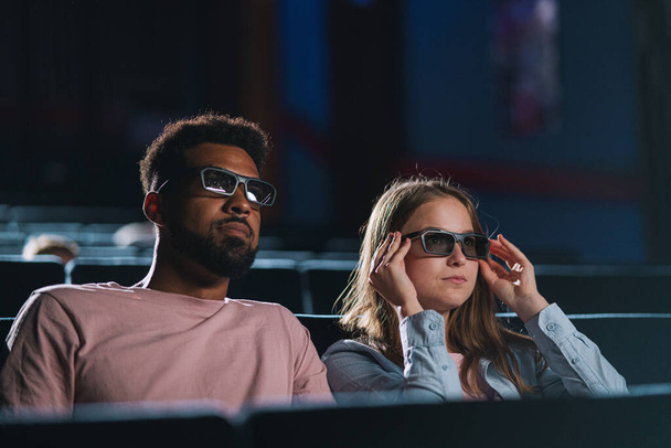 Cheerful young couple with 3d glasses in the cinema, watching film. - Фото, зображення