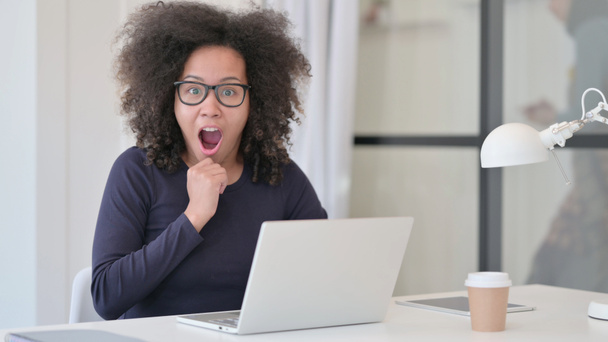 Femme africaine se sentant choquée tout en utilisant un ordinateur portable  - Photo, image