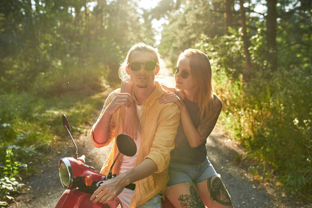Happy young caucasian man and woman sitting on scooter - Photo, Image