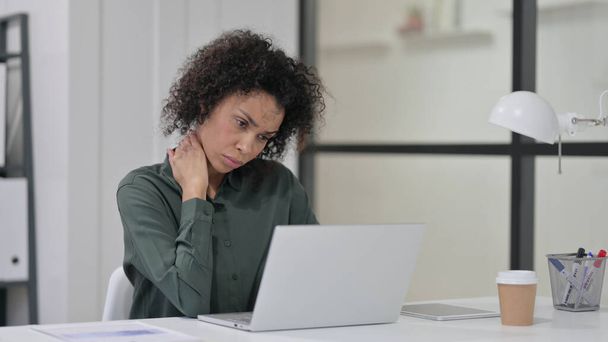 Afrikanerin hat Nackenschmerzen, während sie Laptop benutzt - Foto, Bild