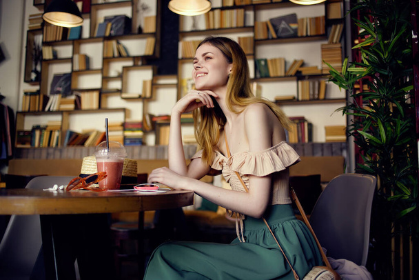 mooie vrouw zitten aan een tafel met een drankje in een cafe Lifestyle - Foto, afbeelding