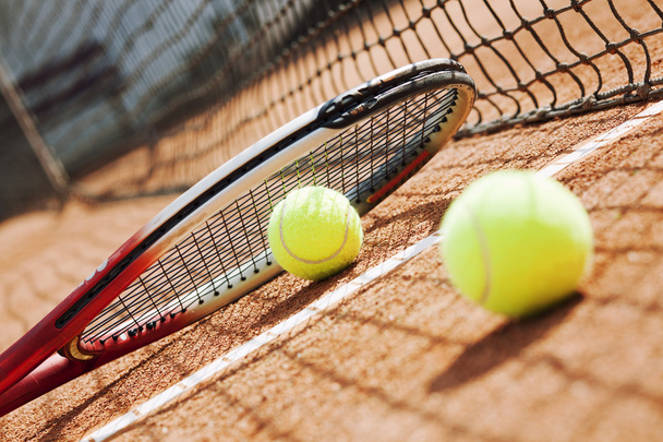 Close up of tennis racquet and balls on the clay tennis court - Fotó, kép