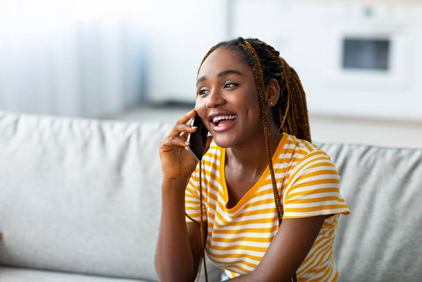 Nahaufnahme einer positiven schwarzen Frau, die telefoniert - Foto, Bild