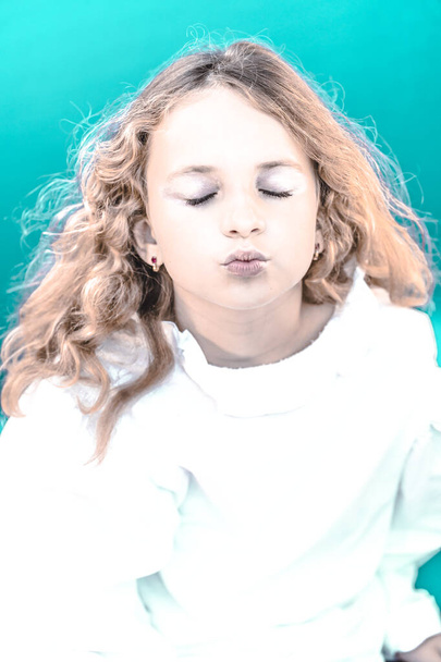 Emotionaalinen muotokuva nuori kaunis tyttö kihara tukka. Naismalli studio ammuttiin sinistä taustaa vasten, hämärtynyt tarkennuksen tausta.  - Valokuva, kuva