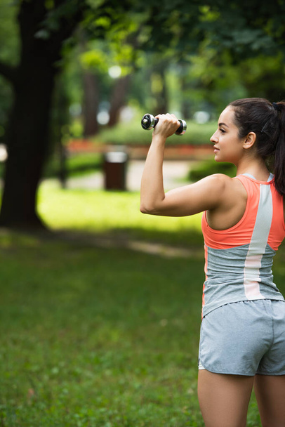 deportista fuerte haciendo ejercicio con la mancuerna en el parque - Foto, Imagen