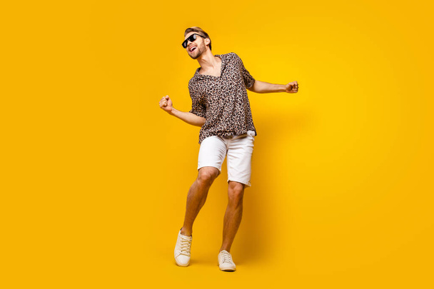 Full length photo of funky lucky gentleman dressed print shirt dark glasses dancing rising fist isolated yellow color background - Фото, зображення