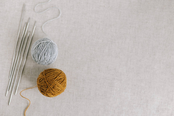 Bolas acolhedoras de fios e agulhas para tricotar. Antecedentes para a vida doméstica artesanal e lenta. Lugar para texto. - Foto, Imagem