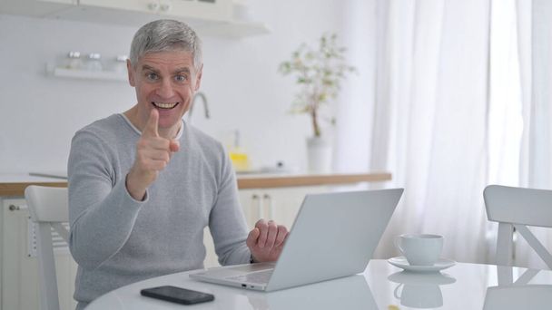 Pozytywny starzec z laptopem pokazuje Tak Znak z Finger - Zdjęcie, obraz