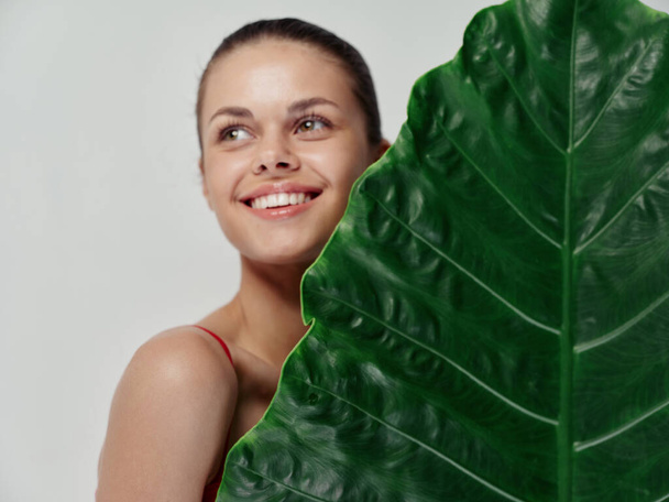 веселая женщина с пальмовым листом в студии крупным планом. Высокое качество фото - Фото, изображение