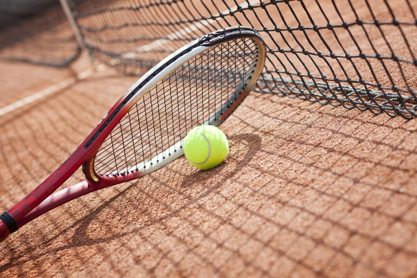 Close up of tennis racquet and balls on the clay tennis court - 写真・画像
