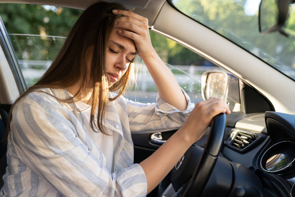 Κουρασμένη νεαρή γυναίκα οδηγός αυτοκινήτου υποφέρουν από πονοκέφαλο ή ημικρανία πόνο στο εσωτερικό του οχήματος αφής μέτωπο - Φωτογραφία, εικόνα