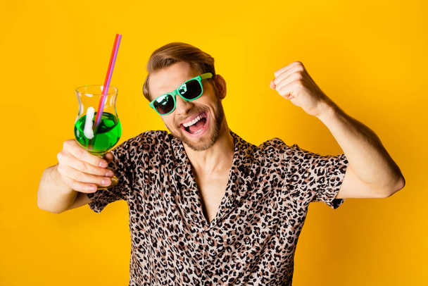 Photo of funny lucky young guy wear leopard outfit dark eyewear rising fist drinking alcohol isolated yellow color background - Φωτογραφία, εικόνα