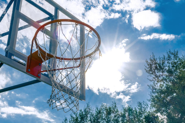 Basketbalový koš proti modré obloze. Nízkoúhlý pohled - Fotografie, Obrázek