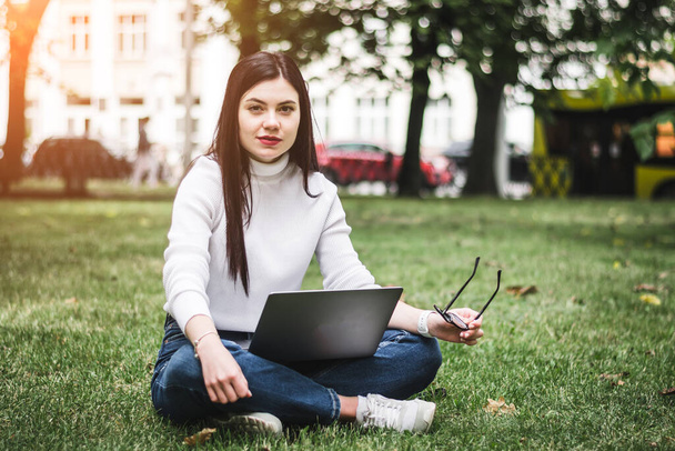 Caucasian Student girl working with a laptop in a green park - Fotó, kép