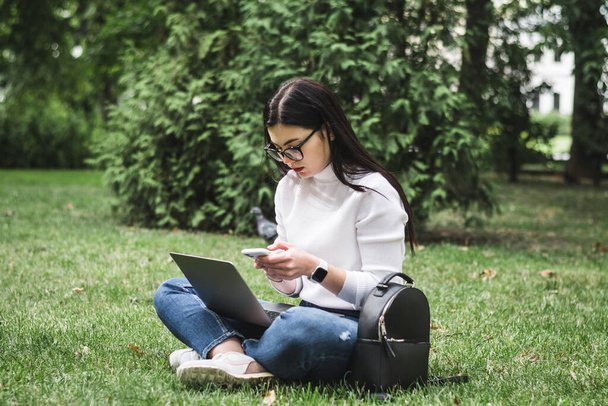 Caucasian Student girl working with a laptop in a green park - Valokuva, kuva
