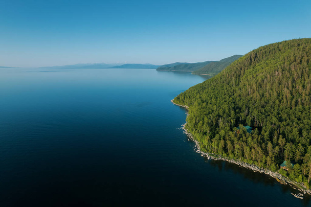 Summertime beelden van het Baikalmeer is een kloof meer gelegen in het zuiden van Siberië, Rusland Baikal meer zomer landschap uitzicht vanaf een klif in de buurt van Grandmas Bay. Drones Eye View. - Foto, afbeelding