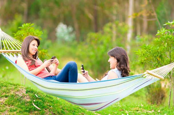 Two young girls resting on a hammock smiling - Photo, Image