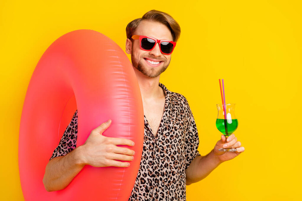 Photo of sweet cute gentleman dressed print shirt arm glasses holding swim circle drinking cocktail isolated yellow color background - Foto, imagen