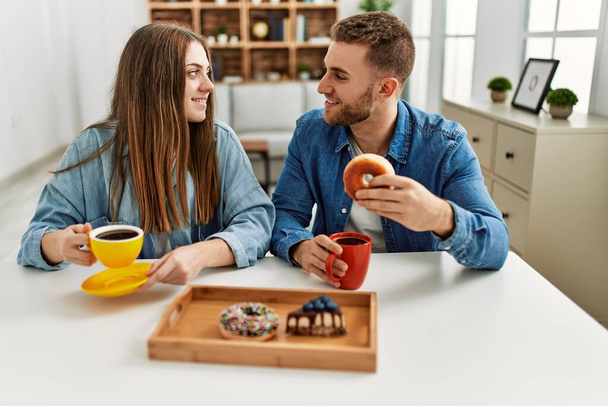 Jovem casal caucasiano tomando café da manhã em casa. - Foto, Imagem