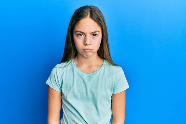 Beautiful brunette little girl wearing casual white t shirt depressed and worry for distress, crying angry and afraid. sad expression.  - Foto, Bild