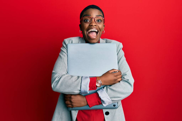 Fiatal afro-amerikai üzletasszony kezében laptop ünnepli őrült és csodálkozott a siker nyitott szemmel sikoltozó izgatott.  - Fotó, kép