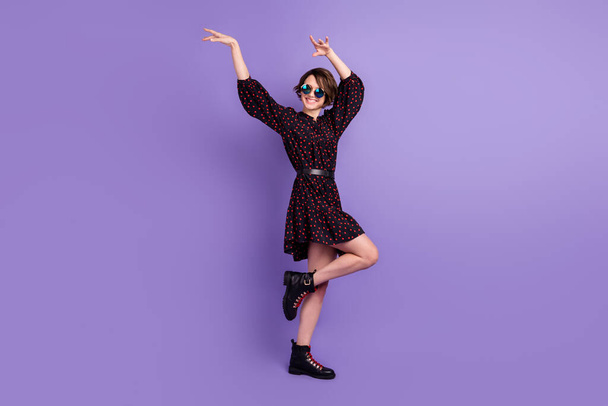 Volledige lengte lichaamsgrootte uitzicht van aantrekkelijke vrolijke meisje dansen met plezier tijdverdrijf geïsoleerd over heldere paarse kleur achtergrond - Foto, afbeelding