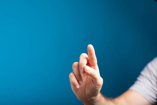 A closeup shot of a man's hand touching with finger - Fotó, kép