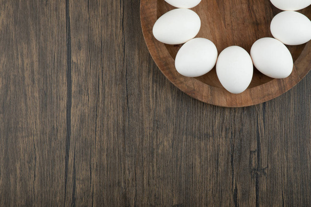 Surowe białe jaja i butelka oliwy z oliwek na drewnianej desce. Wysokiej jakości zdjęcie - Zdjęcie, obraz