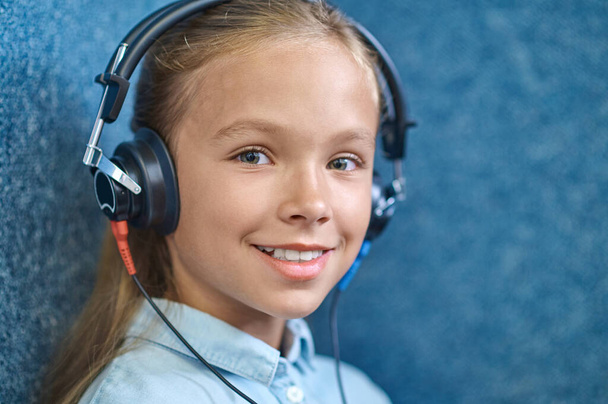 Smiling beautiful female patient in headphones looking ahead - Foto, Imagen