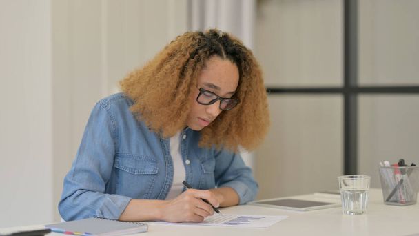 Afrikanerin liest Dokumente bei der Arbeit  - Foto, Bild