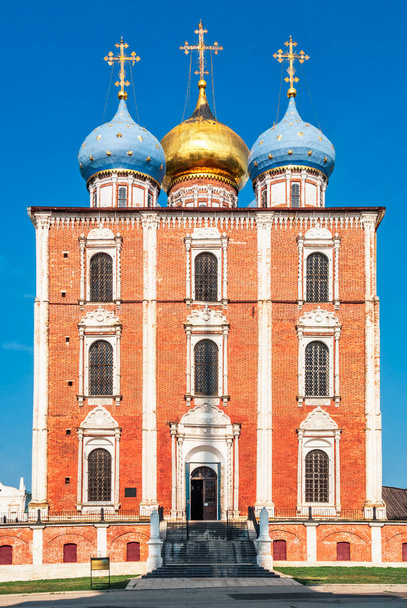 gevel en hoofdingang van de Dormition kathedraal van het Ryazan Kremlin op een zomerse dag tegen een blauwe lucht - Foto, afbeelding