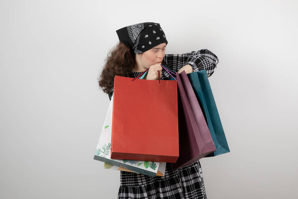 Portrait de jeune fille avec le syndrome du duvet regardant tas de sac à provisions. Photo de haute qualité - Photo, image