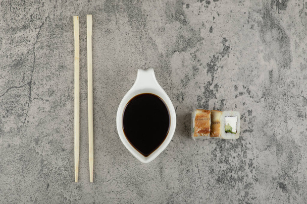 Traditional soy sauce and sushi rolls with eel on stone background. High quality photo - Photo, Image