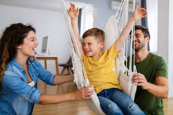 Счастливая молодая семья веселится, играя вместе дома - Фото, изображение
