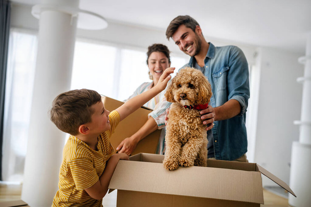 Boldog család dobozokat pakol ki az új otthonban a költözés napján. Emberek, ingatlan, új otthon koncepció - Fotó, kép