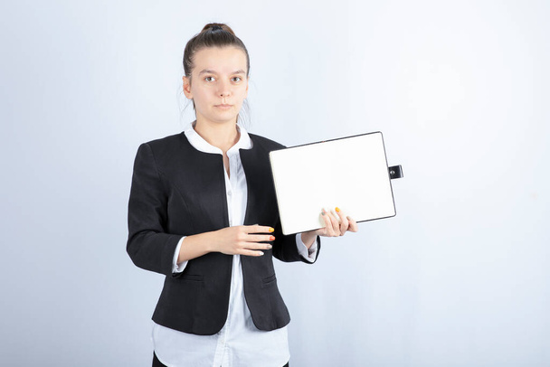 Portrait of young female teacher holding notebook on white background. High quality photo - 写真・画像