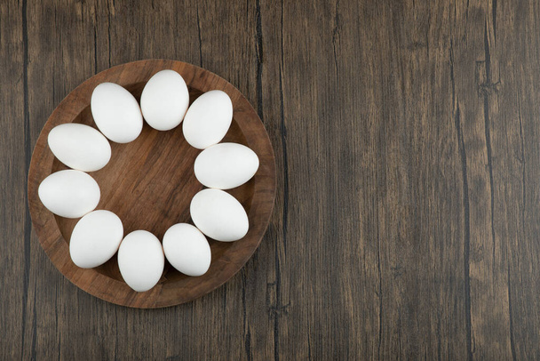 Puinen kartonki raaka orgaanisia munia puupinnalla. Laadukas kuva - Valokuva, kuva