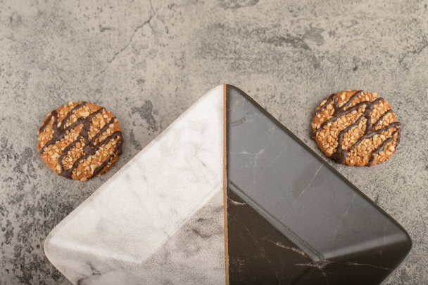 Σπιτικά μπισκότα βρώμης με ξηρούς καρπούς και άδειο μπολ σε πέτρα. Υψηλής ποιότητας φωτογραφία - Φωτογραφία, εικόνα