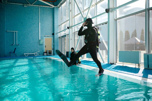 Mergulhador em equipamento de mergulho salta para a piscina, mergulho - Foto, Imagem