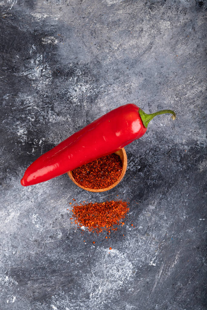 Rode chili peper met gemalen peper vlokken op marmer. Hoge kwaliteit foto - Foto, afbeelding