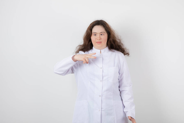 Porträtfoto eines jungen Models mit Down-Syndrom, das mit weißer Uniform steht. Hochwertiges Foto - Foto, Bild