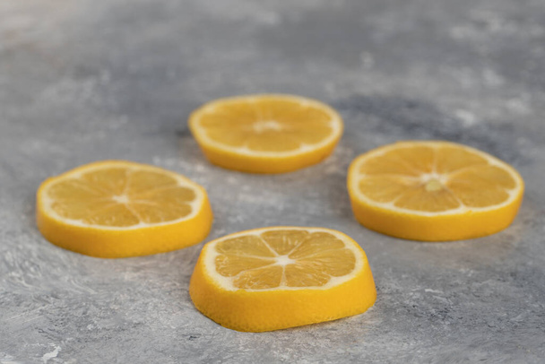 Four slices of sour lemon on a marble background . High quality photo - Photo, Image